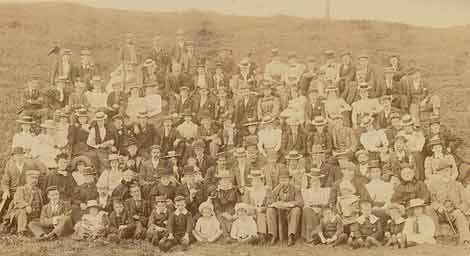 Photo of a large group of Edwardian people seated outdoors