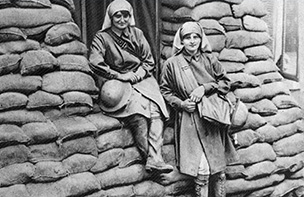 Two nurses at a wall of sandbags