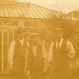 Photo of men outside a large greenhouse