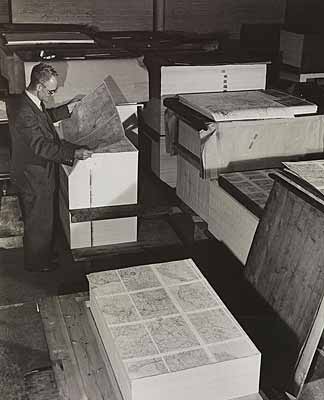 Photo of a man checking a maps sheet