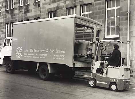 Photo of van being loaded by a man in a small fork-lift vehicle