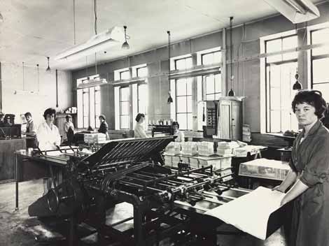 Photo of women at machines for folding maps