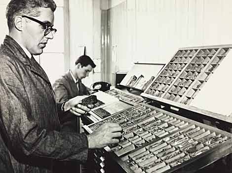 Photo of men setting up blocks of type