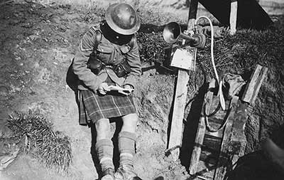 Scottish solder reading in a First World War trench