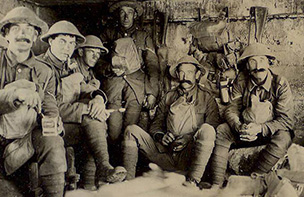 Soldiers in dugout with gas masks hanging round necks