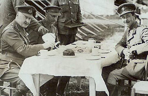 Officers seated at table outdoors having tea