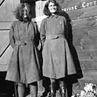 Two women outside wooden building