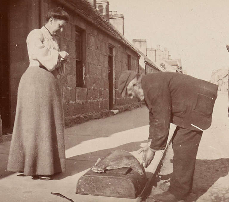 Photograph of woman buying meat on doorstep
