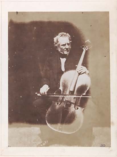 Hugh Lyon Playfair, seated with a cello. 
Playfair was an accomplished musician.