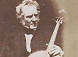 Hugh Lyon Playfair, seated with a cello. 
Playfair was an accomplished musician.