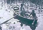Photo of men in boat among water lilies